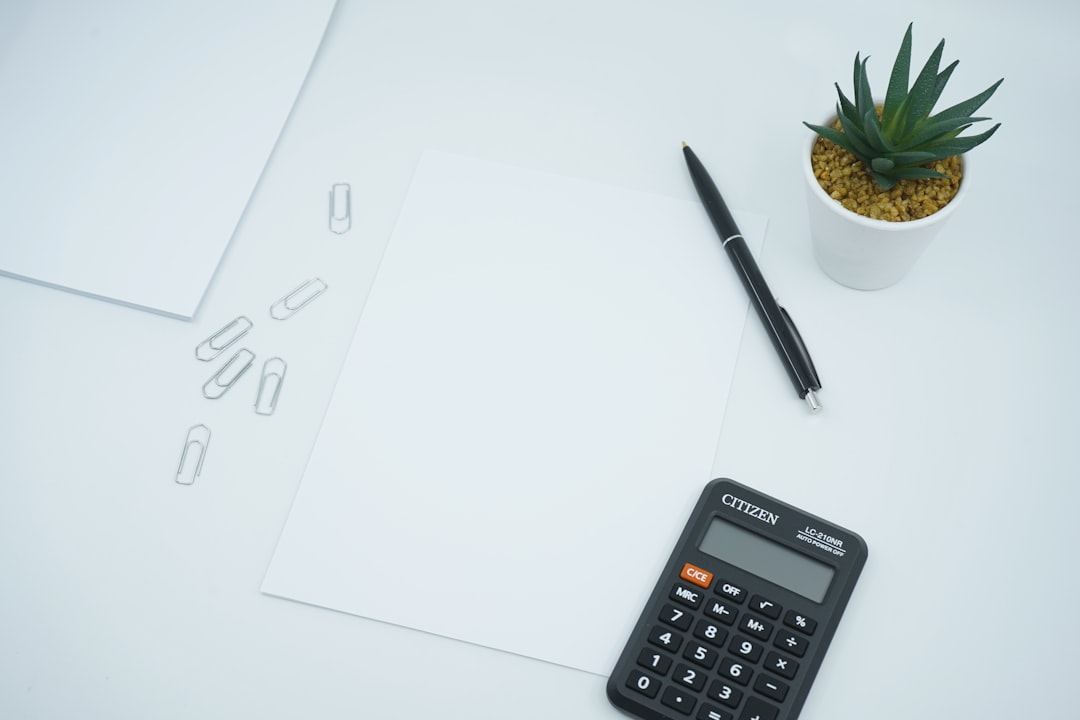 Leeres Blatt Papier mit Stift und Taschenrechner auf dem Schreibtisch