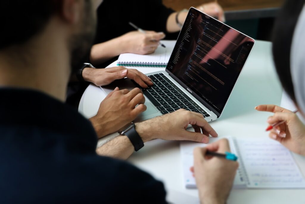 Team bespricht Zahlen am Laptop zum Thema Wachstum und Belastung