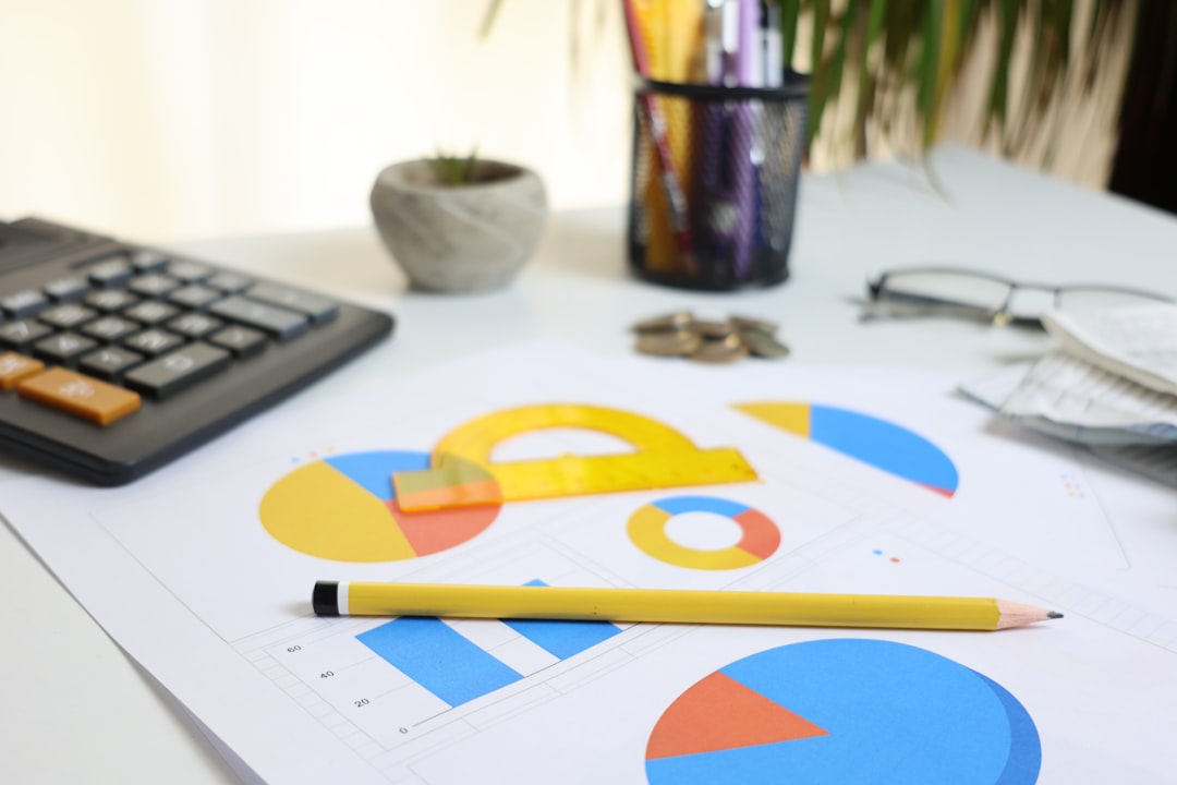 Schreibtisch mit Taschenrechner, Diagrammen und Stift zur Bewertung von Investitionsentscheidungen