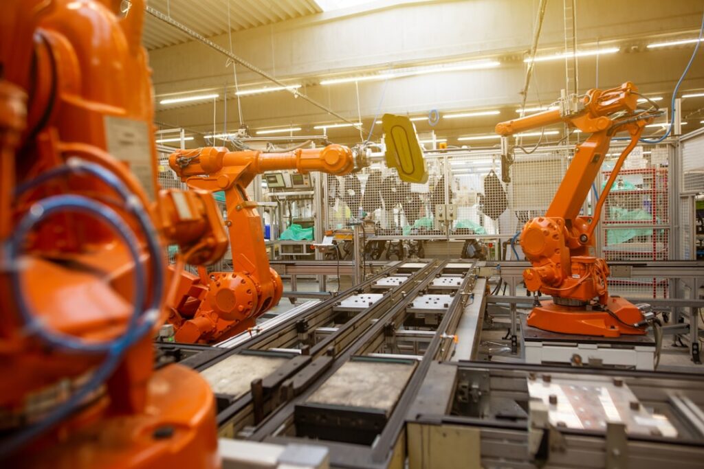 Industrieroboter in einer Fertigungshalle als Symbol fuer Investitionen in Technik und Maschinen