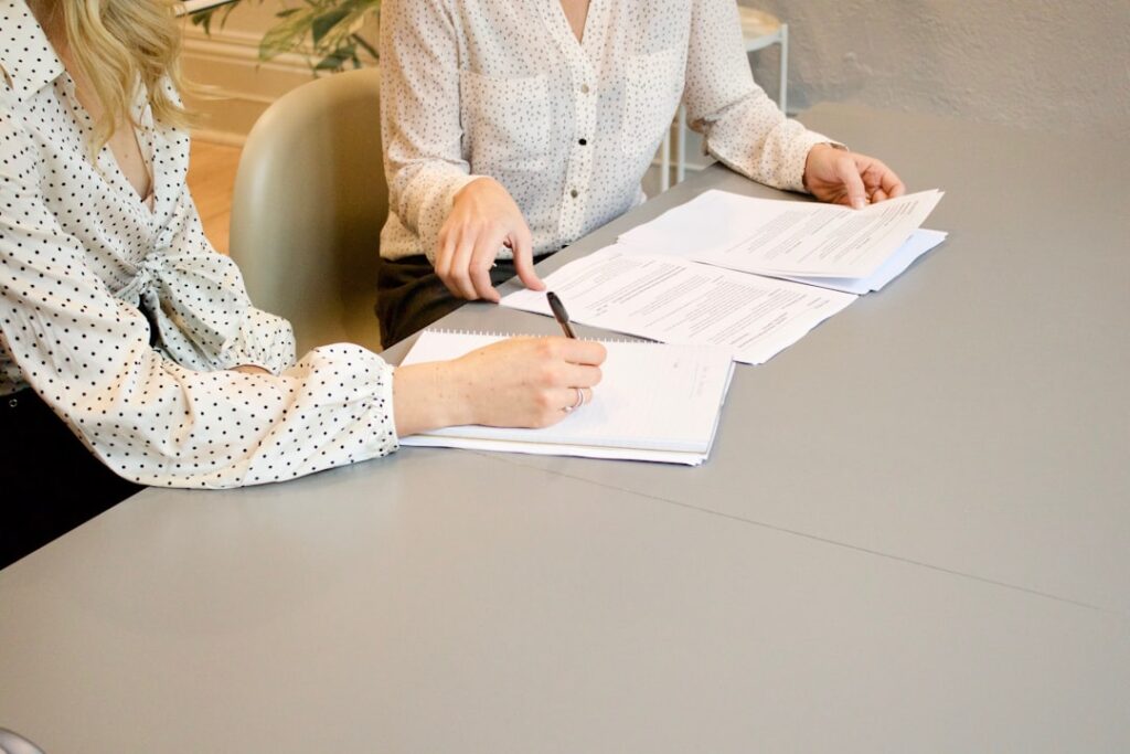 Zwei Personen unterzeichnen Unterlagen zur Foerderform Zuschuss oder Darlehen