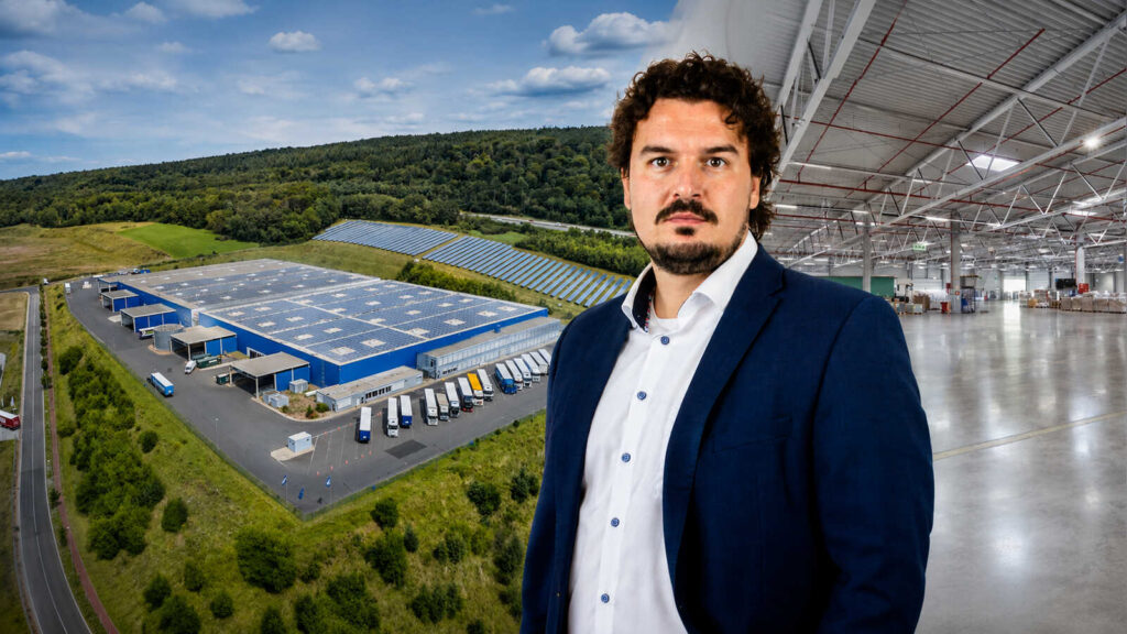 Nikolja Grabowski, Vorstand der ELVIS AG, vor einem Logistikzentrum mit Lkw-Verladung